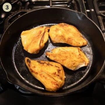 searing four chicken breasts in a skillet.