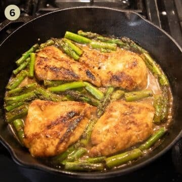simmering chicken and asparagus in a skillet.