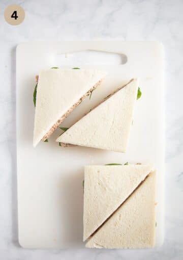 tramezzini cut into triangles on a cutting board.