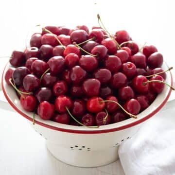 a vintage sieve full with fresh ripe cherries.