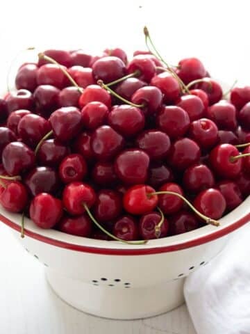 a vintage sieve full with fresh ripe cherries.