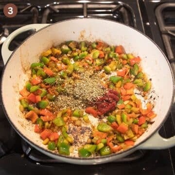 sauteing diced peppers and carrots in a pot.