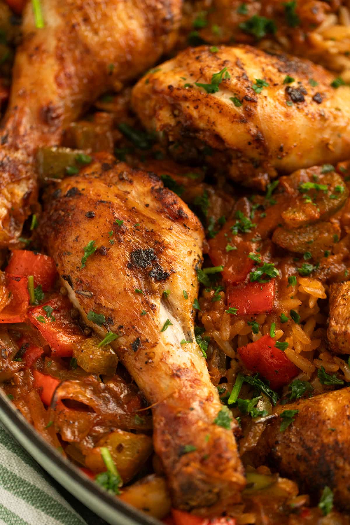 chicken drumsticks and rice with peppers in a pot.