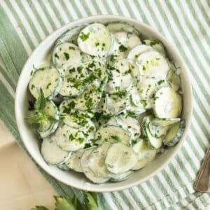 cucumber and yogurt salad with mint and parsley in a bowl.