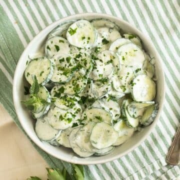 cucumber and yogurt salad with mint and parsley in a bowl.