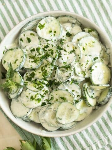 cucumber and yogurt salad with mint and parsley in a bowl.