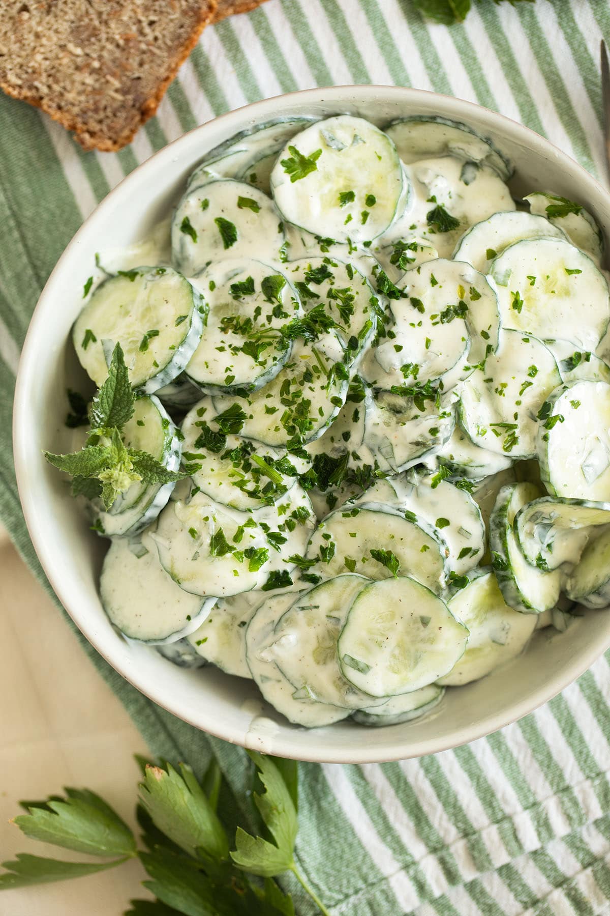 bowl full of cucumber salad with yogurt dressing.