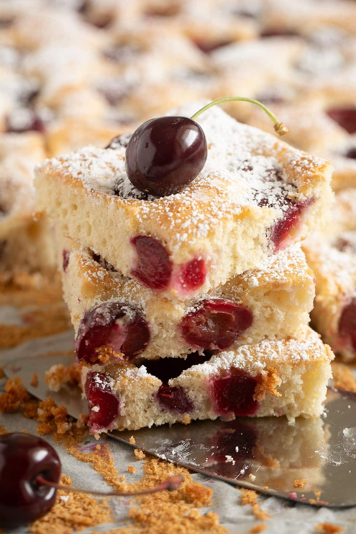 three stapled pieces of german cherry cake with a fresh cherry on top.