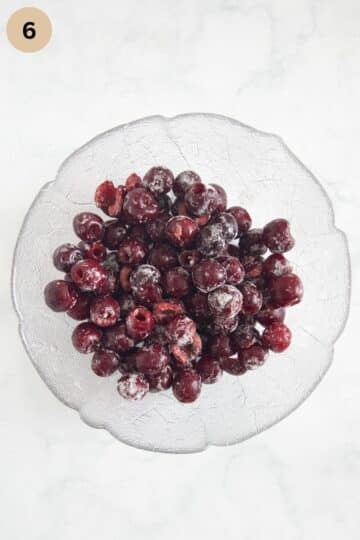 pitted fresh cherries tossed with flour in a bowl.