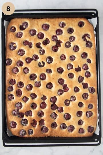 golden baked cherry cake on a baking sheet.