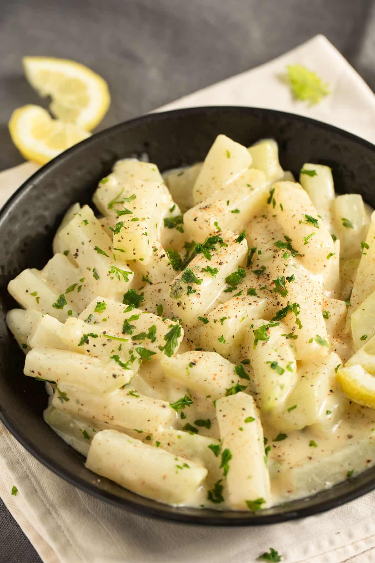 creamy kohlrabi german-style sprinkled with parsley in a bowl.