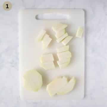 fresh kohlrabi cut into thick strips on a cutting board.