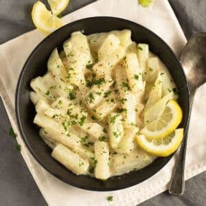 creamy german kohlrabi served in a bowl with lemon wedges.