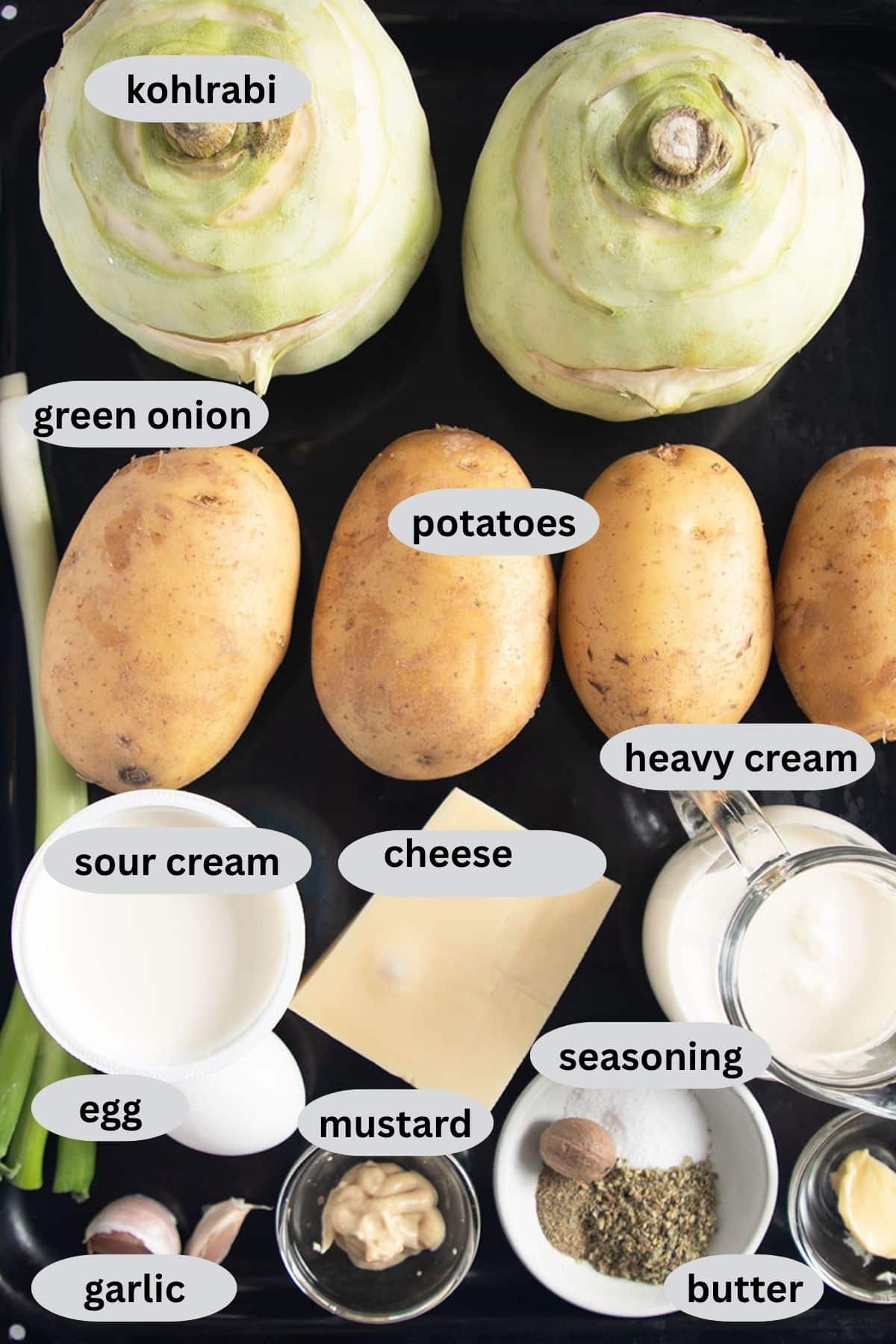 labeled ingredients for making gratin with kohlrabi, potatoes, cream, sour cream, cheese, and seasoning.