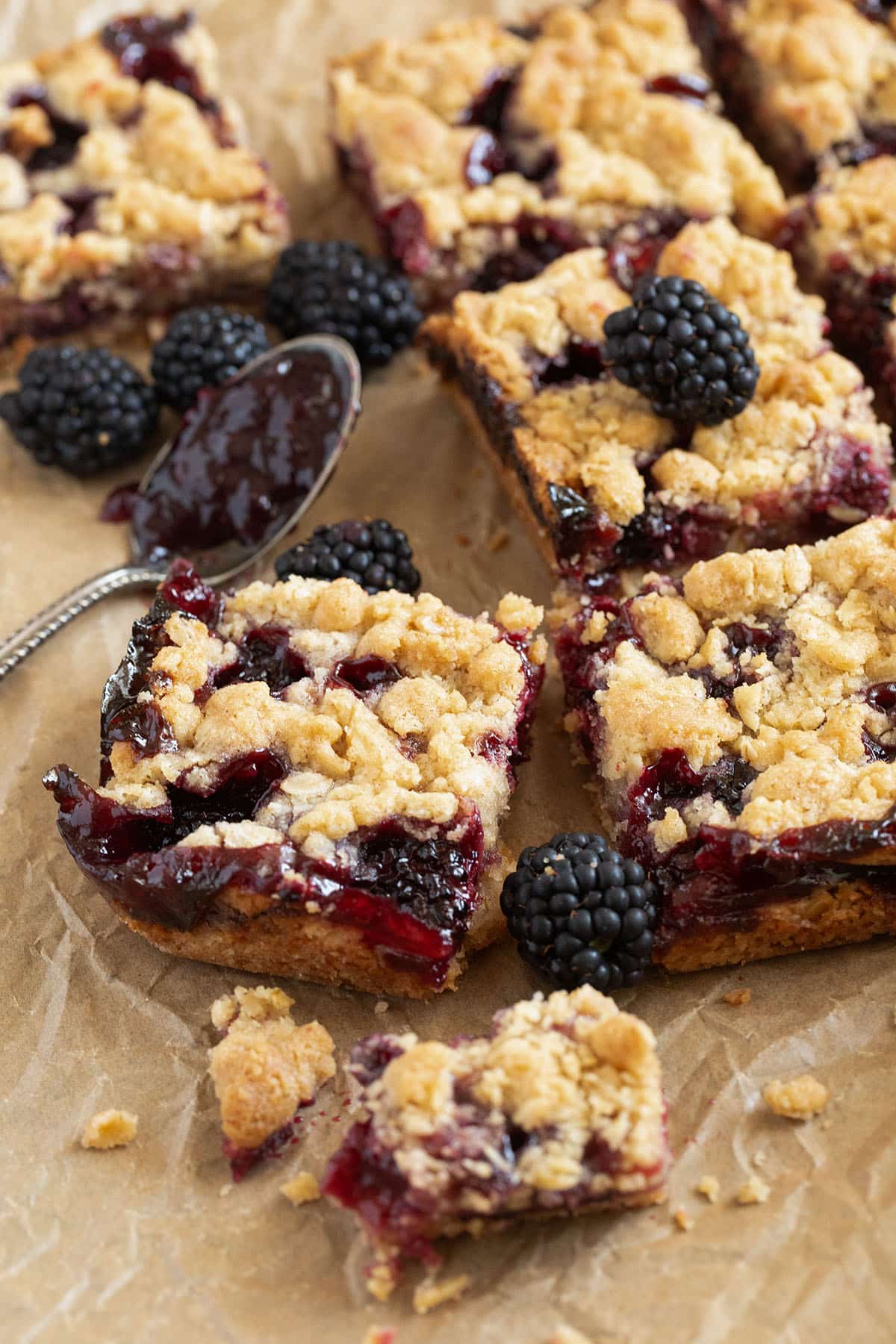 blackberry bars cut into pieces on parchment paper.