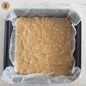 dough for making crumble bars pressed into a small baking dish.