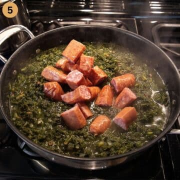 adding chunks of sausage to a pot of german kale.