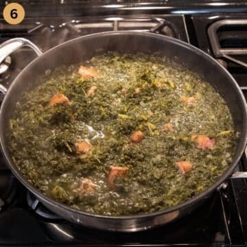 simmering sausages in a pot f kale.