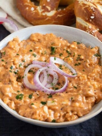 german obatzda recipe with red onions on top in a small bowl.