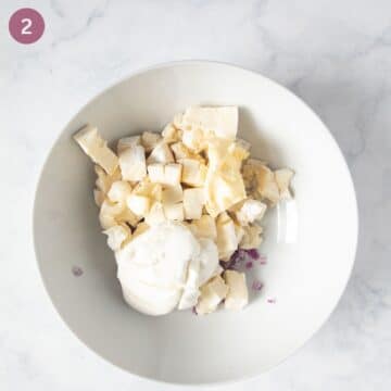 chopped camembert, red onions and cream cheese for making obatzda in a bowl.
