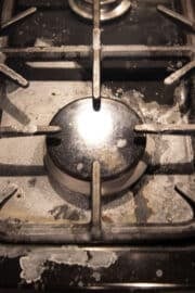 dirty stovetop after spilling baking soda bath.