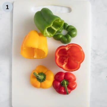 three cleaned peppers ready for stuffing on a cutting board.