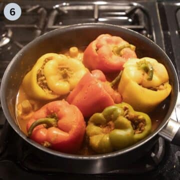 cooked stuffed peppers with rice and mushrooms in a pot.