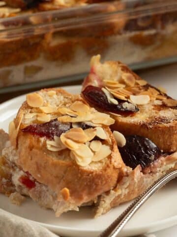 slices of plum bread pudding with a fork on a small plate.
